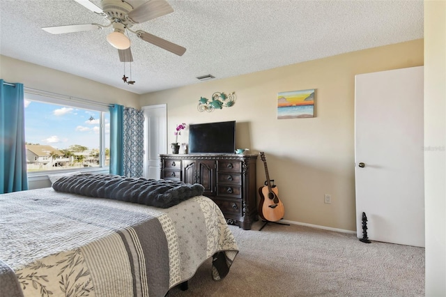 bedroom featuring ceiling fan, light carpet, and a textured ceiling