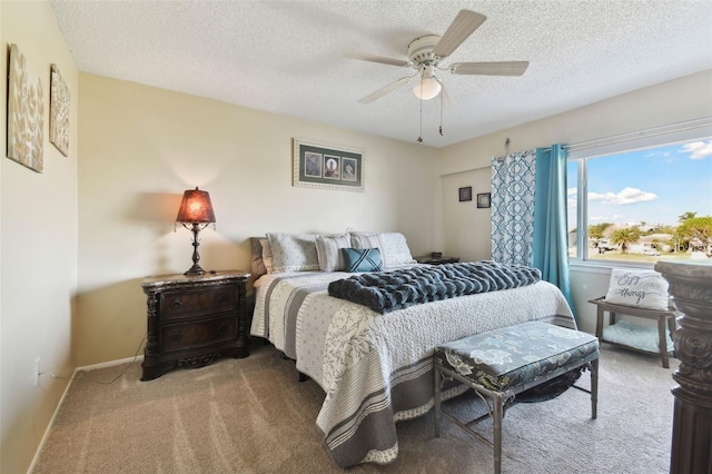 carpeted bedroom featuring ceiling fan and a textured ceiling