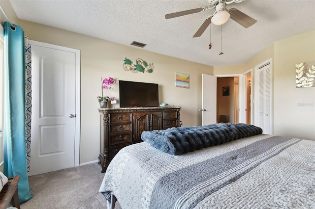 carpeted bedroom with ceiling fan and a textured ceiling