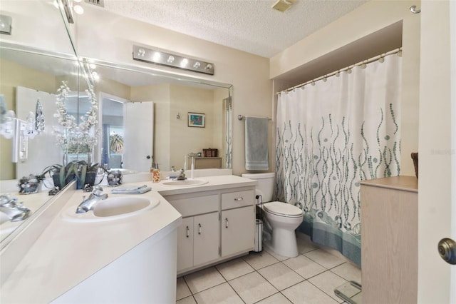 bathroom with tile patterned floors, vanity, a textured ceiling, and toilet