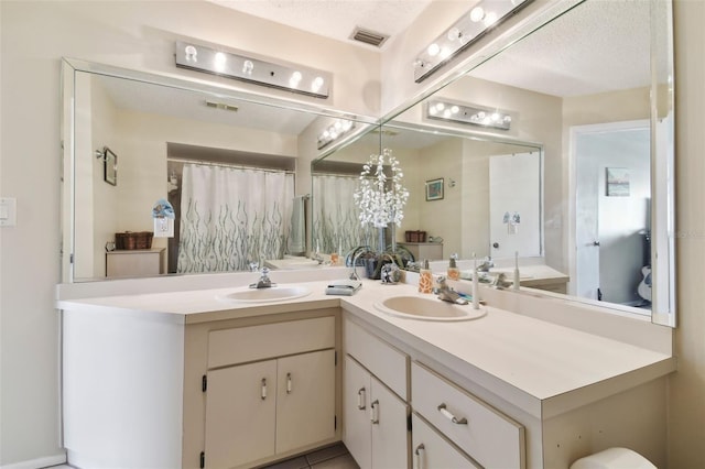 bathroom featuring tile patterned flooring, vanity, and a textured ceiling