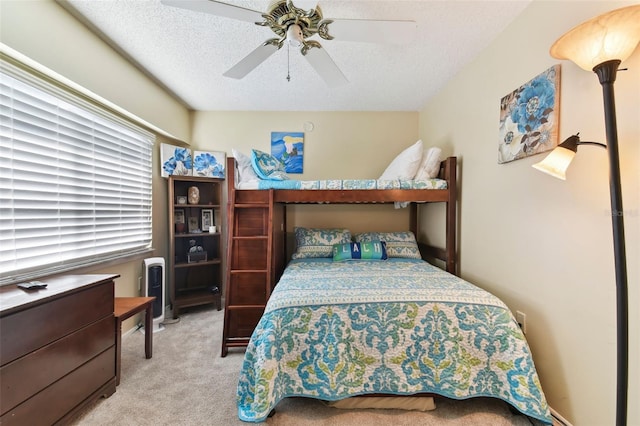 bedroom featuring a textured ceiling, ceiling fan, and light carpet