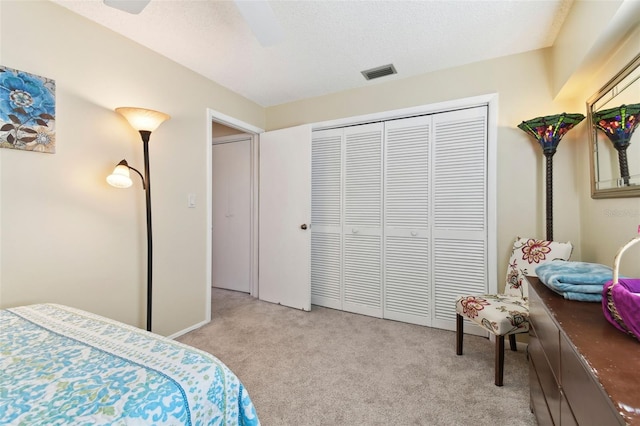 carpeted bedroom with ceiling fan and a closet