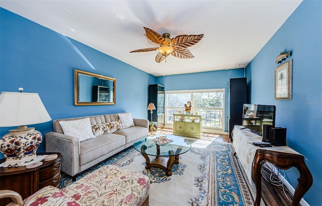 living room with ceiling fan, a textured ceiling, and hardwood / wood-style flooring