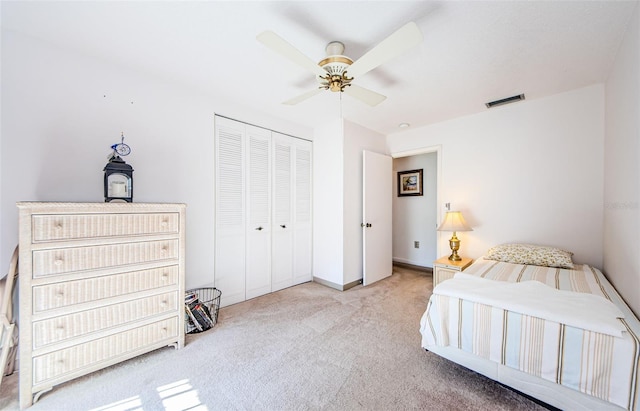 bedroom with light colored carpet, a closet, and ceiling fan