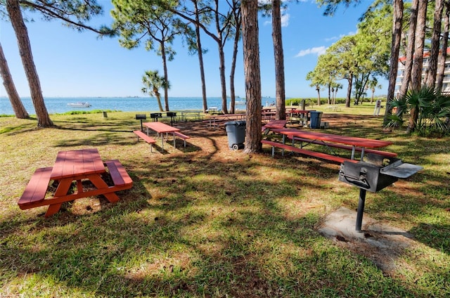 surrounding community with a lawn and a water view