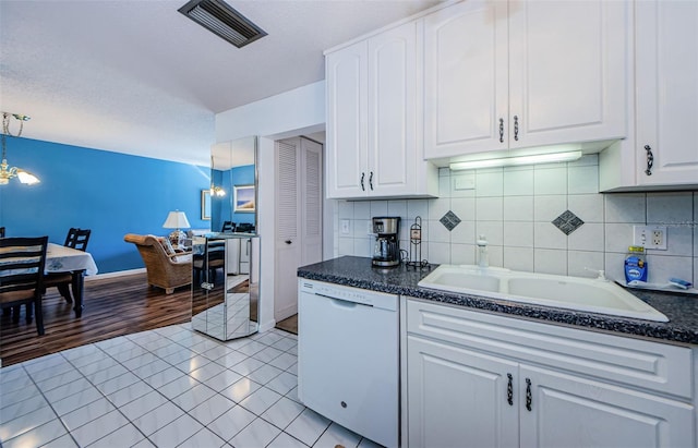 kitchen featuring white cabinets, sink, decorative light fixtures, dishwasher, and light hardwood / wood-style floors