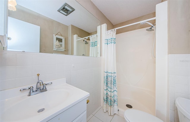 bathroom featuring a shower with shower curtain, a textured ceiling, tile walls, and tile patterned flooring