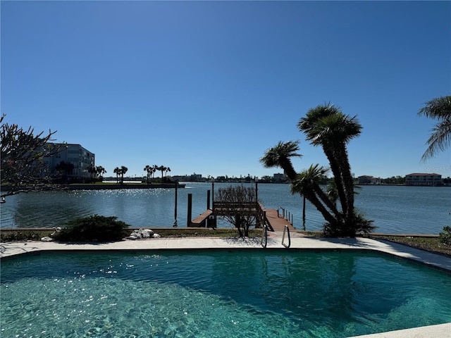 view of swimming pool featuring a water view and a dock