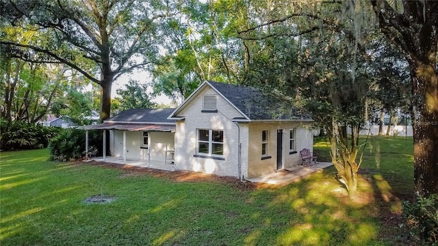 back of house with a patio and a lawn