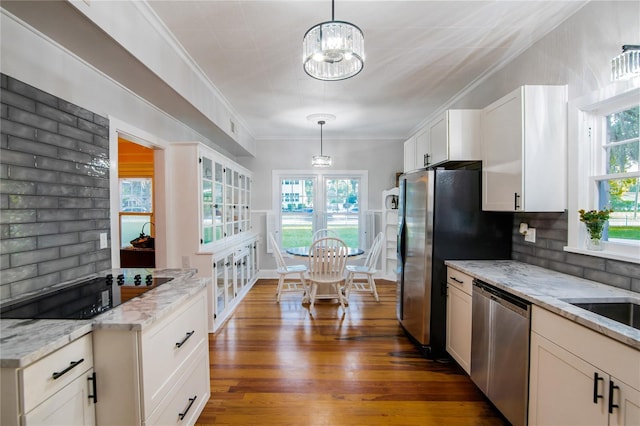 kitchen with pendant lighting, decorative backsplash, light stone countertops, and stainless steel appliances