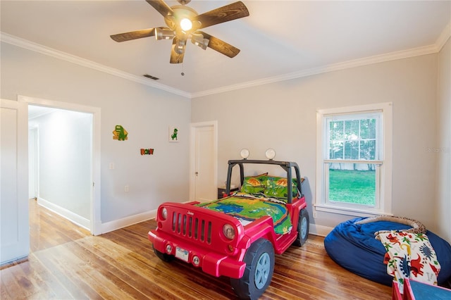 bedroom with hardwood / wood-style flooring, ceiling fan, and ornamental molding