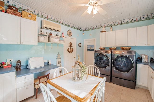 washroom featuring cabinets, an AC wall unit, washer and dryer, ceiling fan, and light tile patterned flooring