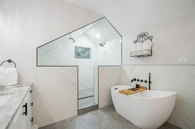 bathroom featuring a bathtub, vanity, and vaulted ceiling