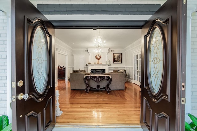foyer featuring an inviting chandelier and ornamental molding