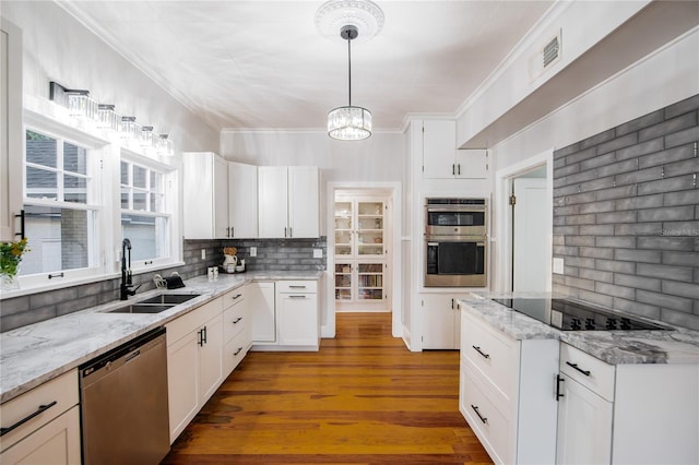 kitchen with tasteful backsplash, ornamental molding, visible vents, a sink, and stainless steel appliances