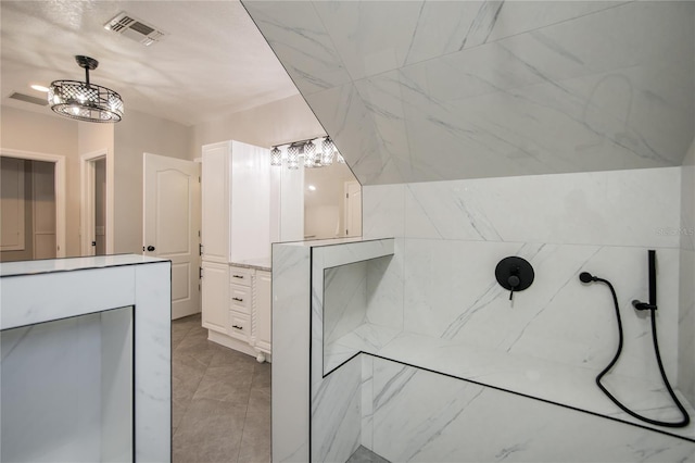 full bathroom with vanity, a marble finish shower, and visible vents