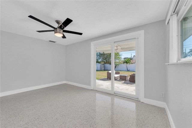 unfurnished room with ceiling fan and a wealth of natural light