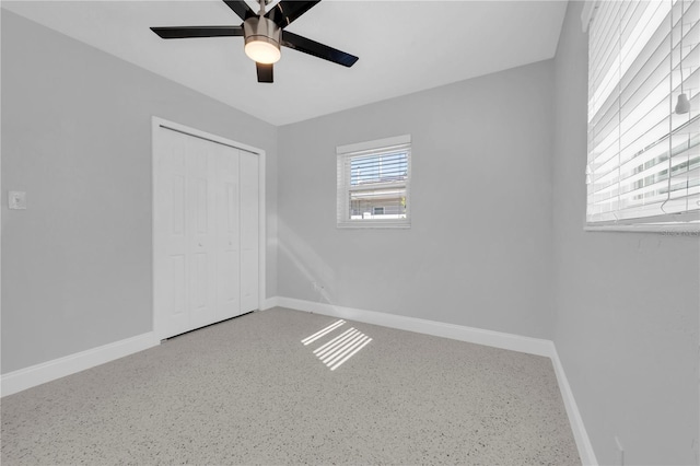 unfurnished bedroom featuring ceiling fan and a closet