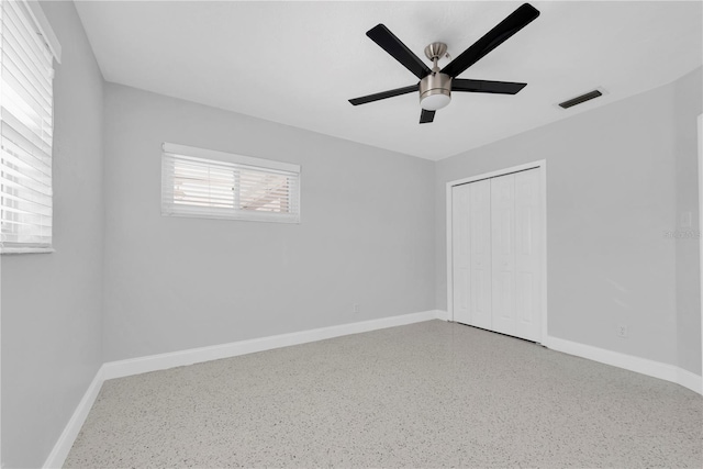 unfurnished bedroom featuring ceiling fan and a closet