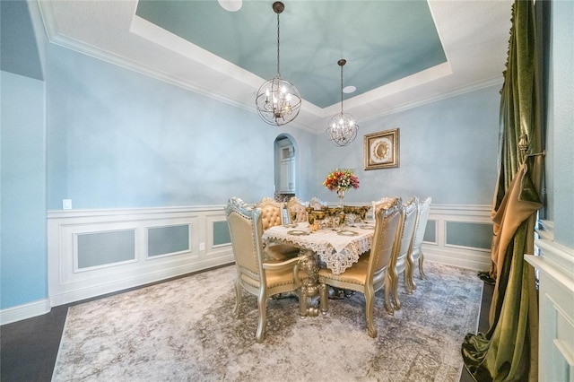 dining room featuring an inviting chandelier, crown molding, and a raised ceiling