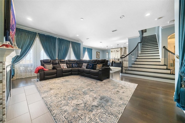 living room with crown molding, plenty of natural light, hardwood / wood-style floors, and a textured ceiling