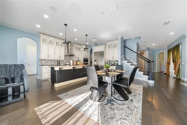 dining area with crown molding and dark hardwood / wood-style flooring