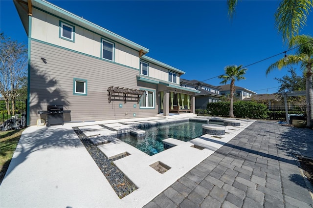 view of swimming pool featuring a grill, a patio area, and an in ground hot tub