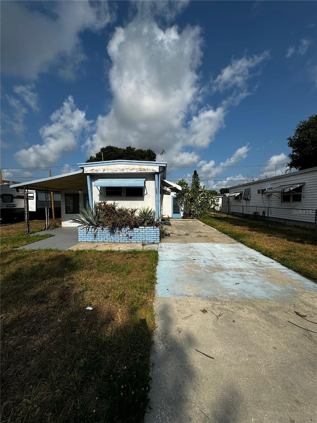 exterior space featuring a carport and a lawn