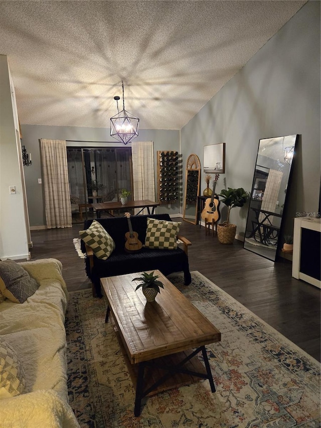 living room featuring lofted ceiling, dark hardwood / wood-style flooring, a chandelier, and a textured ceiling