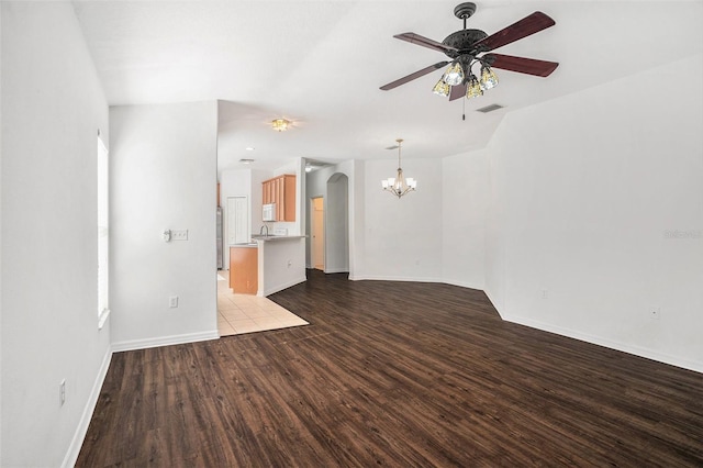 unfurnished living room with ceiling fan with notable chandelier and light hardwood / wood-style flooring