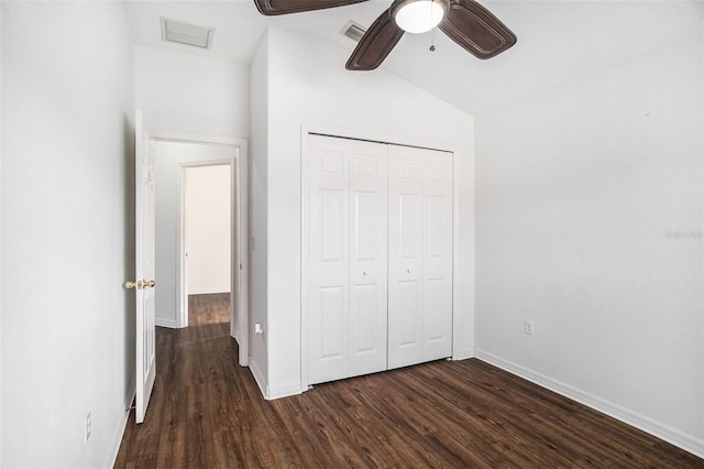 unfurnished bedroom featuring ceiling fan, a closet, dark wood-type flooring, and vaulted ceiling