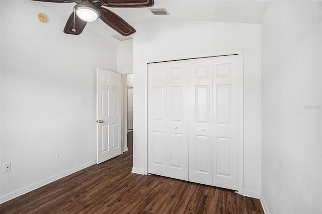 unfurnished bedroom with lofted ceiling, a closet, ceiling fan, and dark wood-type flooring