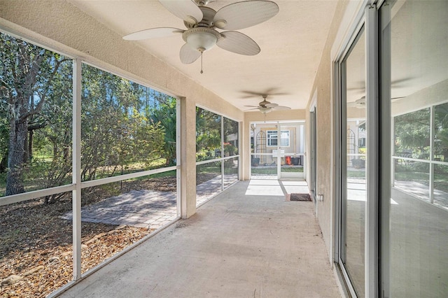 unfurnished sunroom with ceiling fan