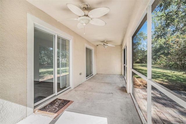 unfurnished sunroom with ceiling fan