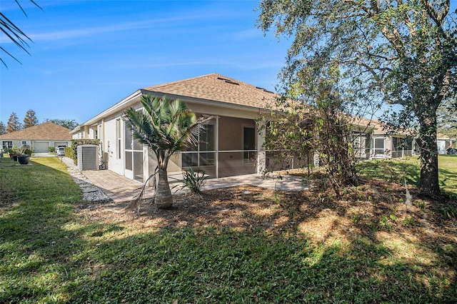 back of house with a sunroom and a lawn