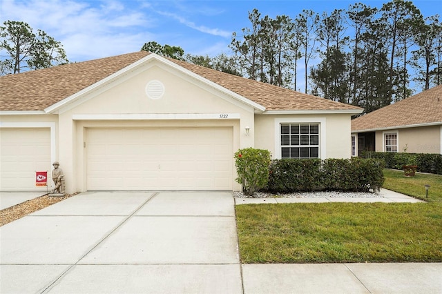 ranch-style house featuring a front lawn and a garage