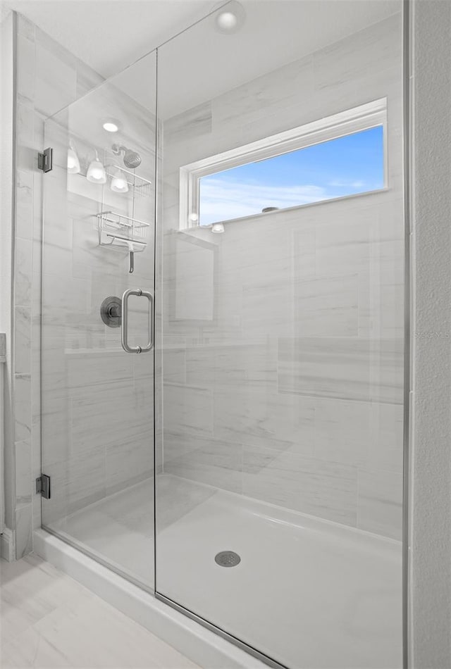 bathroom featuring an enclosed shower and a wealth of natural light