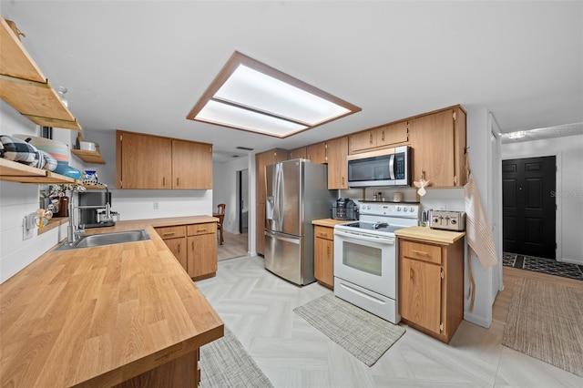 kitchen with stainless steel appliances, light parquet floors, and sink