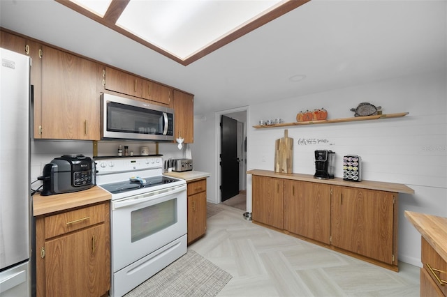 kitchen featuring stainless steel appliances and light parquet flooring