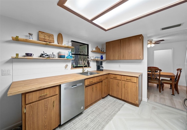 kitchen featuring ceiling fan, sink, stainless steel dishwasher, butcher block countertops, and light parquet flooring