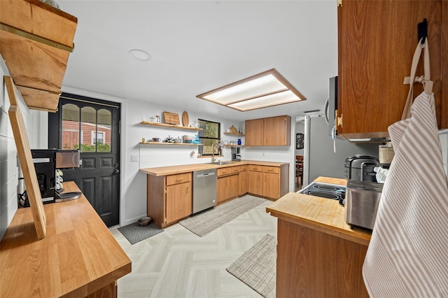 kitchen featuring wood counters, sink, light parquet floors, and appliances with stainless steel finishes