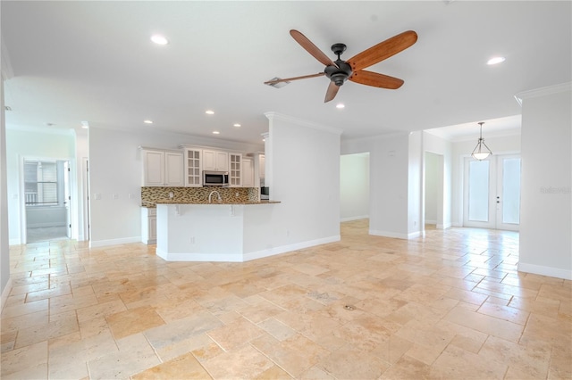 unfurnished living room featuring french doors, ceiling fan, and crown molding