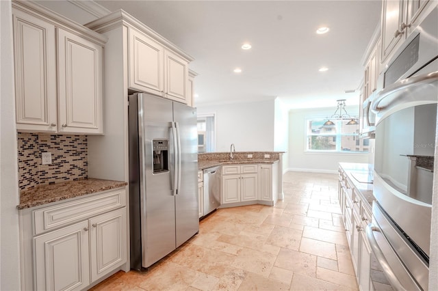 kitchen with decorative backsplash, light stone counters, ornamental molding, and appliances with stainless steel finishes