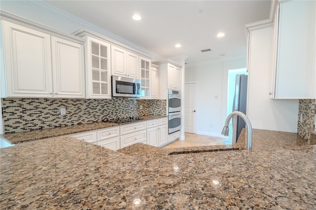 kitchen with white cabinetry, sink, stainless steel appliances, crown molding, and stone countertops