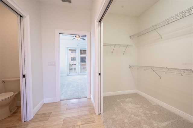 spacious closet featuring light colored carpet and ceiling fan