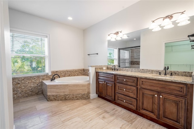 bathroom featuring vanity and independent shower and bath