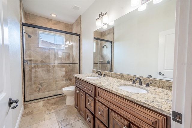 bathroom featuring vanity, toilet, and a shower with shower door