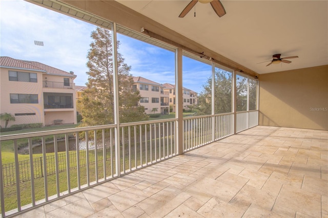 unfurnished sunroom with ceiling fan and a healthy amount of sunlight