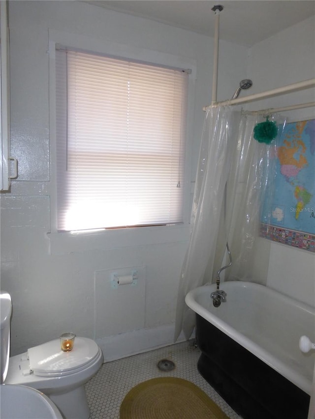 bathroom with tile patterned flooring, toilet, and shower / tub combo with curtain